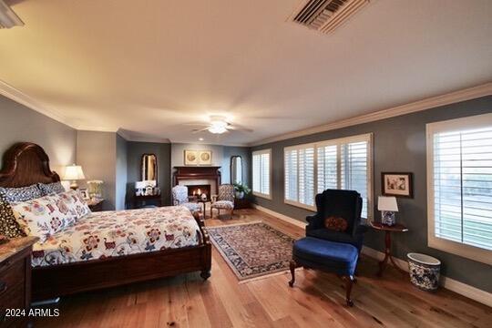 bedroom featuring ornamental molding, light hardwood / wood-style flooring, and ceiling fan