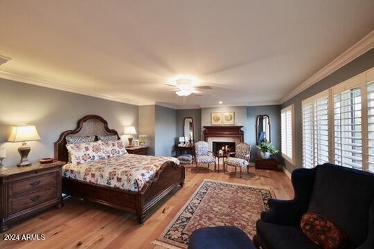 bedroom with light hardwood / wood-style flooring, crown molding, and ceiling fan