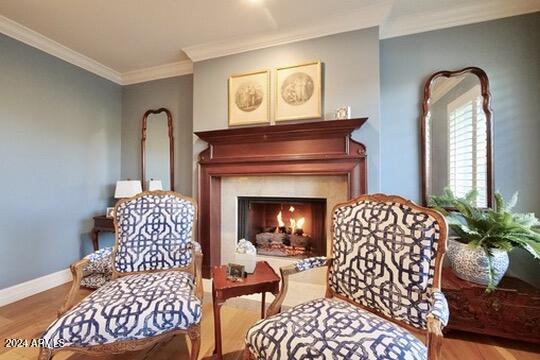 living area featuring crown molding and hardwood / wood-style flooring