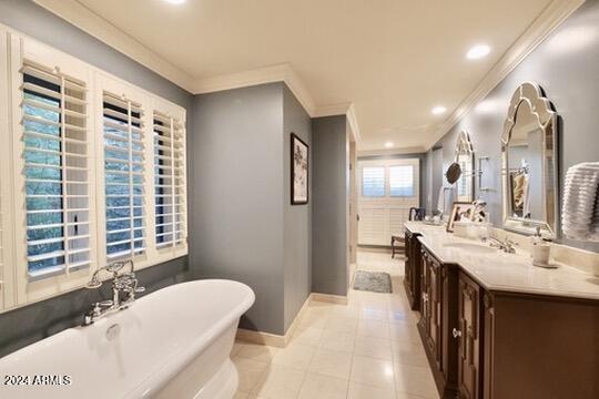 bathroom featuring vanity, a tub, tile patterned flooring, and ornamental molding