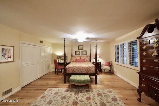 bedroom with a closet, light wood-type flooring, and ceiling fan