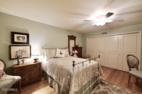 bedroom with a closet, light wood-type flooring, and ceiling fan