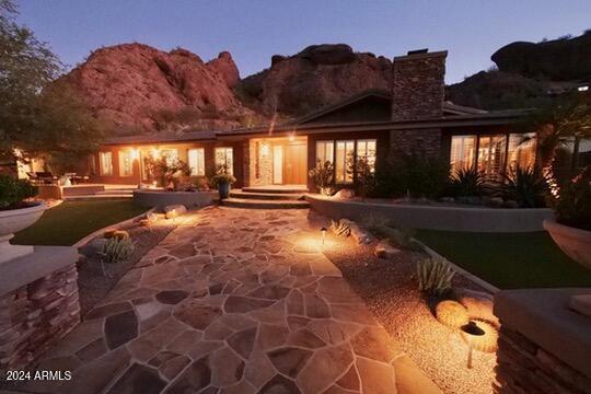 back house at dusk with a patio and a mountain view