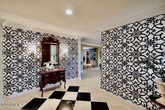 hallway with ornamental molding and light tile patterned floors