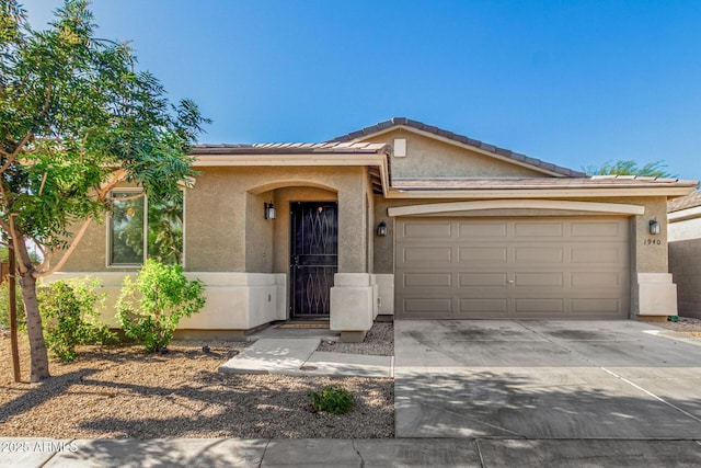 1940 W Expressman St, Apache Junction, AZ 85120 - view of front of home with stucco siding, an attached garage, driveway, and a tiled roof