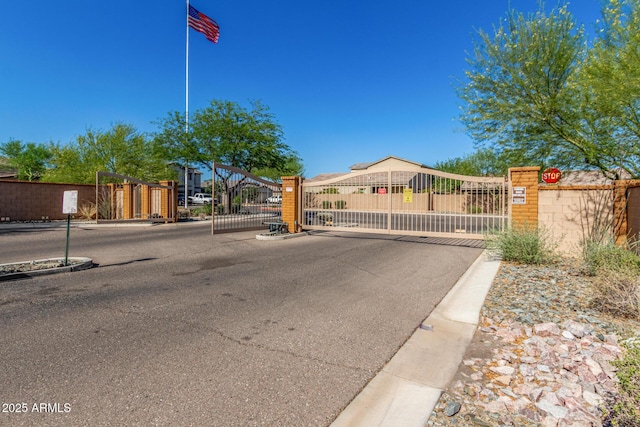 1940 W Expressman St, Apache Junction, AZ 85120 - view of asphalt road featuring a gate, curbs, a gated entry, and traffic signs