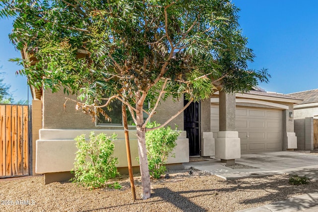 1940 W Expressman St, Apache Junction, AZ 85120 - view of front of house featuring concrete driveway, an attached garage, and stucco siding