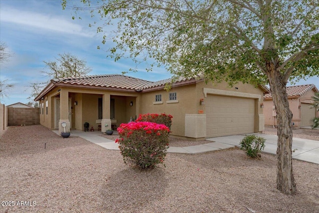 view of front of house featuring a garage, fence, driveway, a tiled roof, and stucco siding