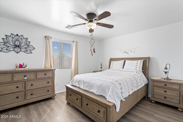 bedroom featuring a ceiling fan, visible vents, light wood-style flooring, and baseboards