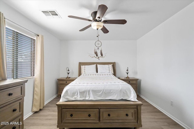 bedroom featuring light wood-type flooring, visible vents, and baseboards