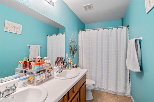 full bath featuring visible vents, a sink, toilet, and double vanity