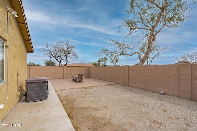 view of yard featuring a patio area, a fenced backyard, and central AC unit