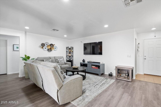 living area featuring recessed lighting, visible vents, and wood finished floors