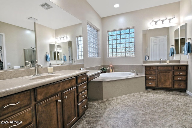 bathroom featuring vanity, tile patterned floors, and tiled tub