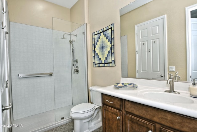 bathroom featuring toilet, vanity, and walk in shower