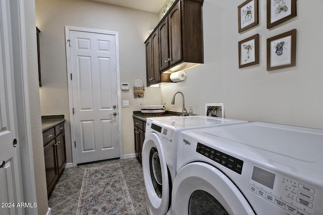 laundry area with cabinets, washing machine and dryer, and dark tile patterned flooring