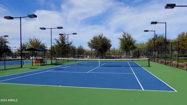 view of tennis court with basketball hoop