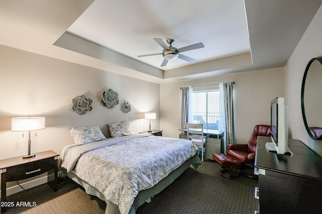 carpeted bedroom featuring a tray ceiling and ceiling fan