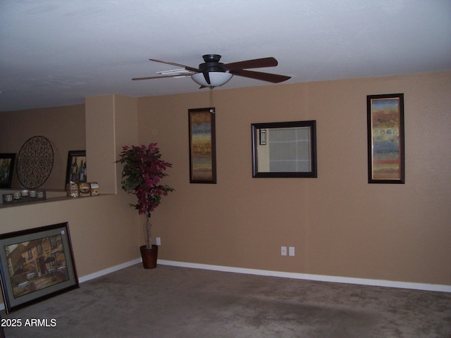 carpeted empty room with ceiling fan and baseboards