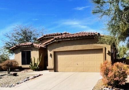 view of front facade with a garage, concrete driveway, stucco siding, and a tiled roof