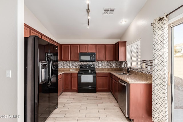 kitchen featuring a wealth of natural light, sink, black appliances, and lofted ceiling