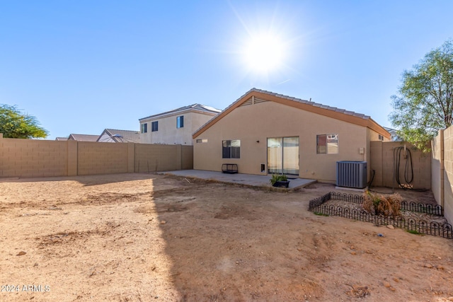 rear view of house with central air condition unit and a patio