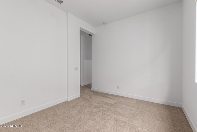 spare room featuring light colored carpet