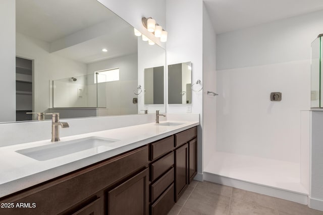 bathroom with a shower, tile patterned floors, and vanity