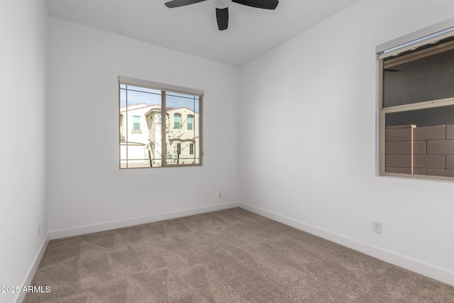 carpeted spare room featuring ceiling fan