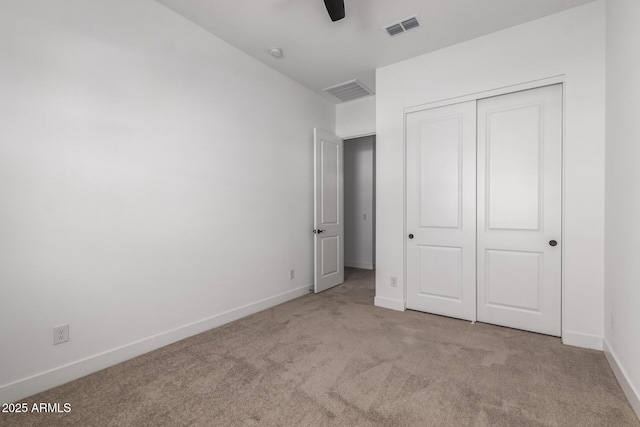 unfurnished bedroom with light colored carpet, a closet, and ceiling fan