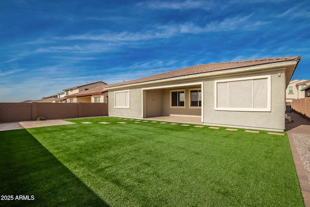 back of house featuring a patio area and a lawn