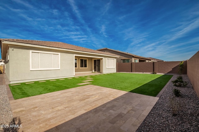 rear view of house featuring a patio area and a yard