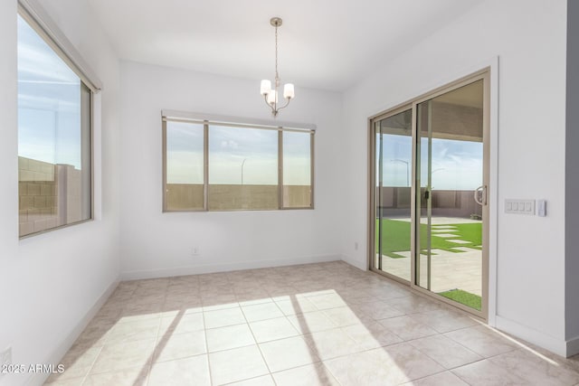 tiled empty room with plenty of natural light and a chandelier