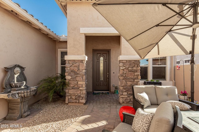 property entrance with a patio area and outdoor lounge area