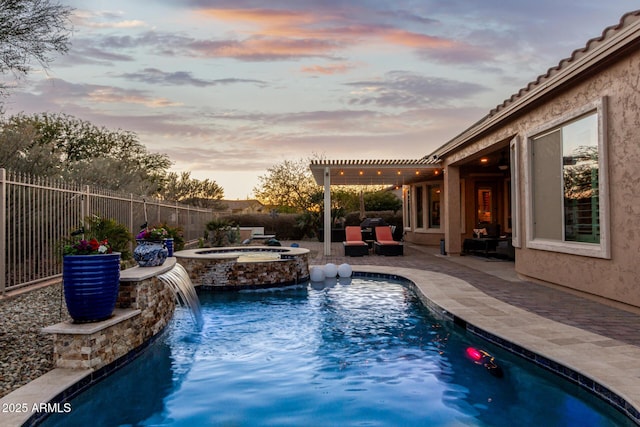 pool at dusk featuring a pergola, pool water feature, a patio area, and an in ground hot tub