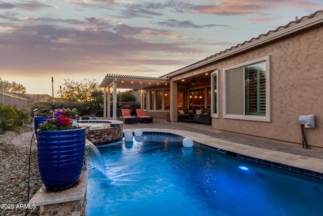 pool at dusk featuring an in ground hot tub, a pergola, pool water feature, and a patio