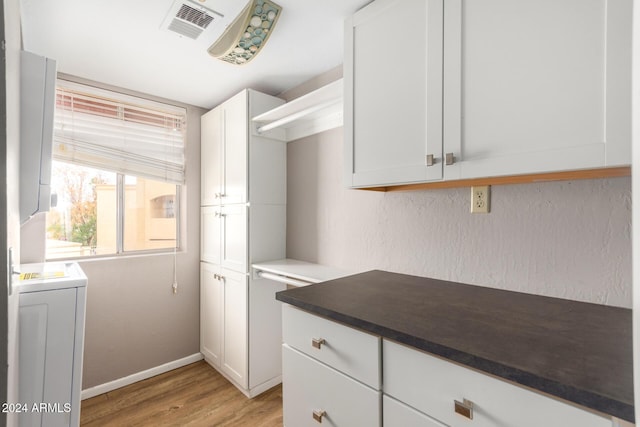 kitchen with white cabinets and light hardwood / wood-style floors