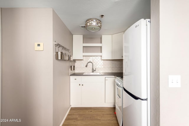 kitchen featuring refrigerator, light hardwood / wood-style floors, decorative backsplash, sink, and white cabinets