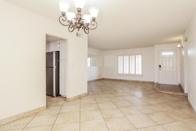 unfurnished dining area with light tile patterned flooring and a notable chandelier