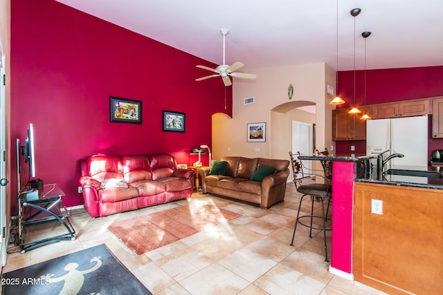 living room with ceiling fan, high vaulted ceiling, and sink