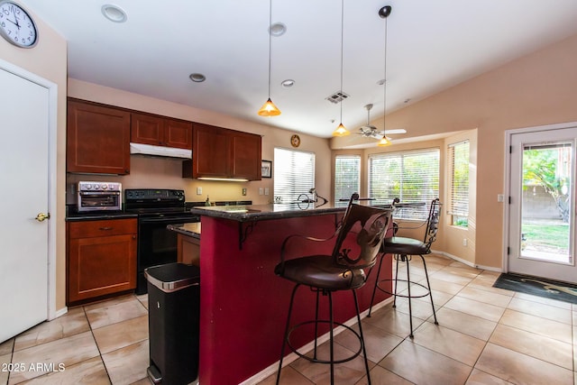 kitchen featuring hanging light fixtures, black electric range, a breakfast bar area, and a kitchen island