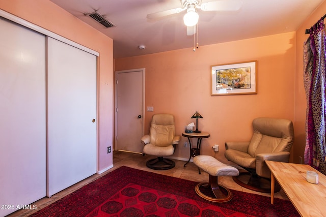 sitting room featuring tile patterned floors and ceiling fan