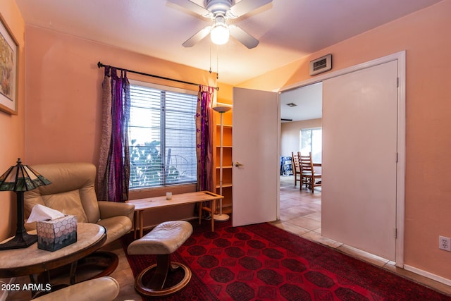 living area featuring light tile patterned flooring and ceiling fan