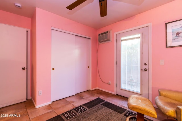 tiled entryway with ceiling fan and a wall unit AC