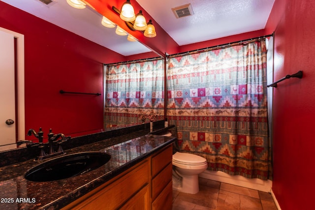 bathroom with vanity, toilet, and a textured ceiling