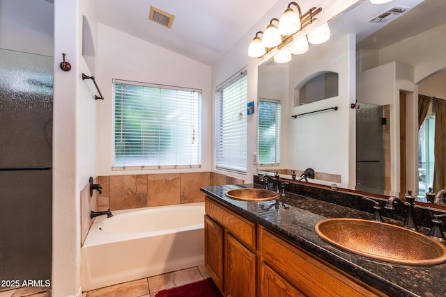 bathroom featuring vaulted ceiling, a tub to relax in, tile patterned floors, and vanity