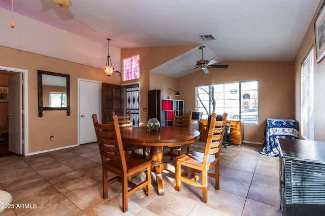 dining space featuring ceiling fan, lofted ceiling, and light tile patterned floors