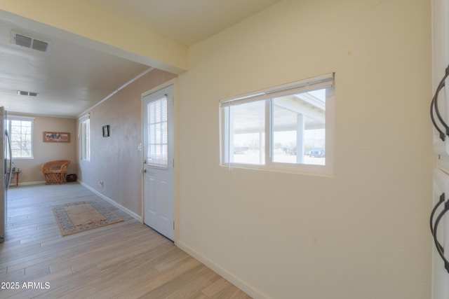 interior space with crown molding and light hardwood / wood-style flooring