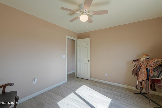 empty room with ceiling fan and light hardwood / wood-style flooring