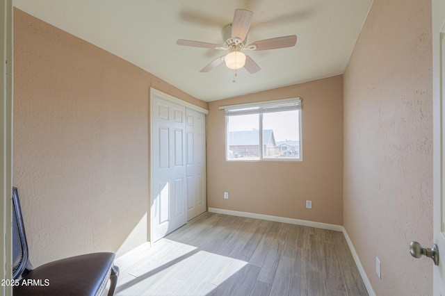 bedroom featuring light hardwood / wood-style floors, a closet, and ceiling fan